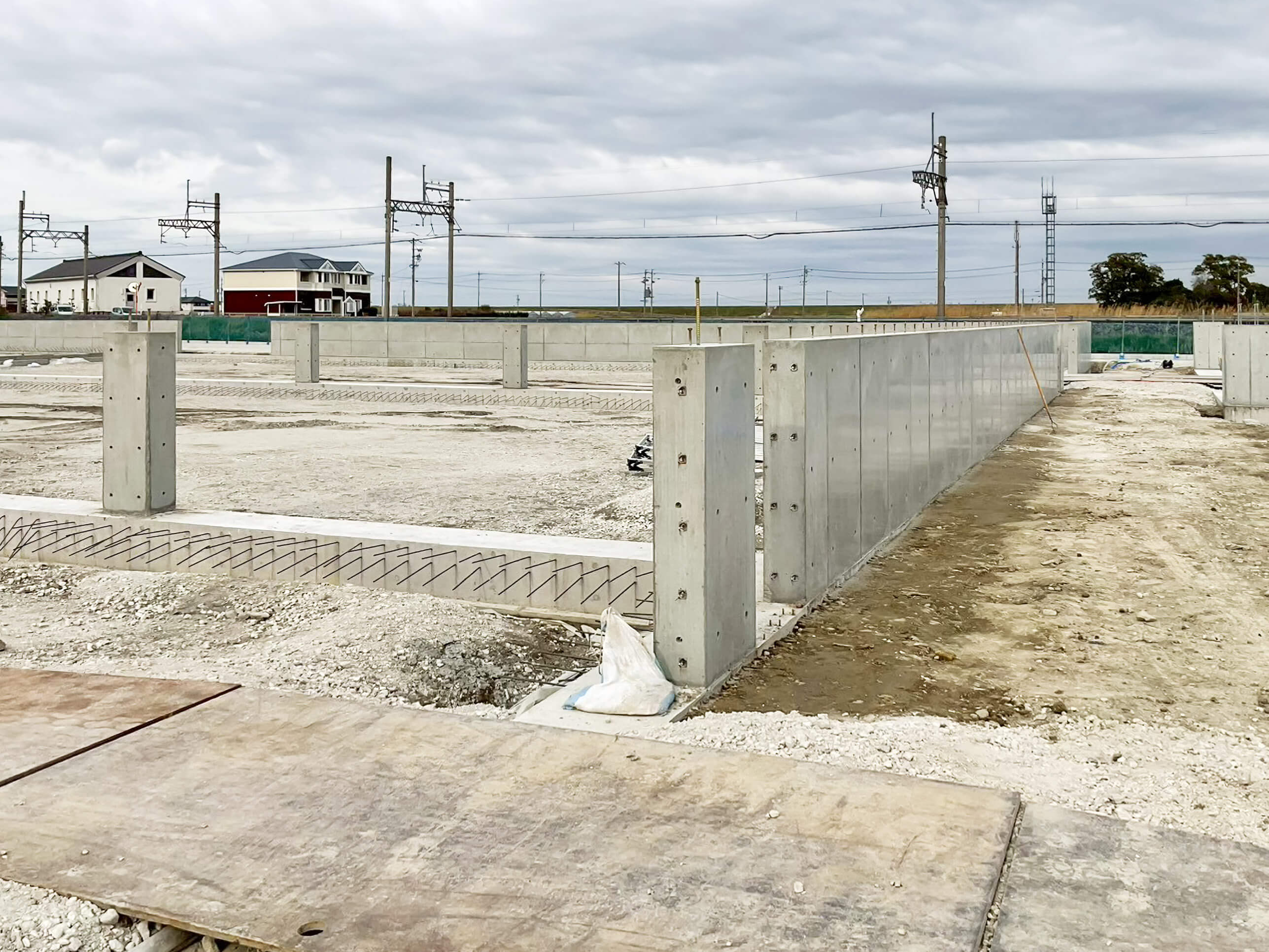 基礎工事の現場で、コンクリート立ち上がりと柱脚が並ぶ